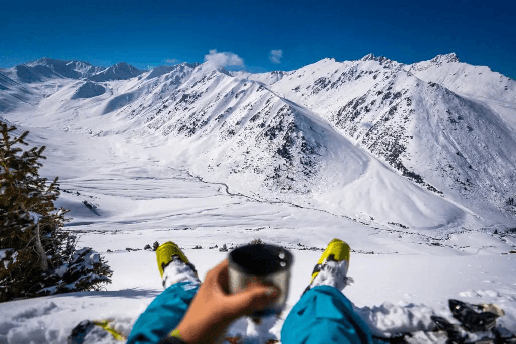 Guy having some wine in a mountain in Kyrgyztan. Ski touring break.