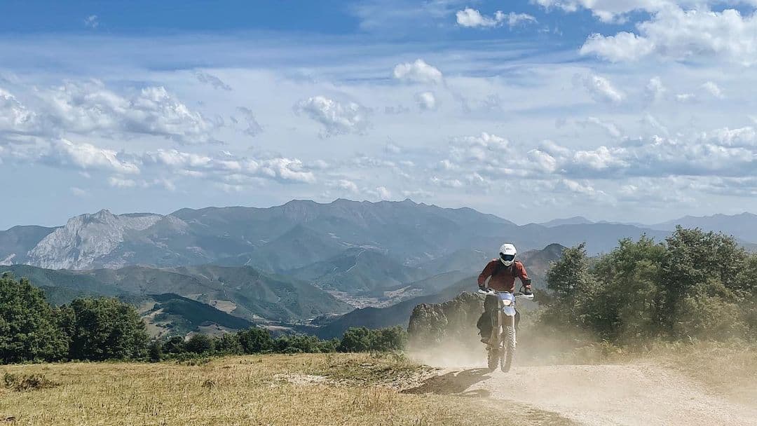 Moto Enduro rider with a mountain landscape in the backdrop