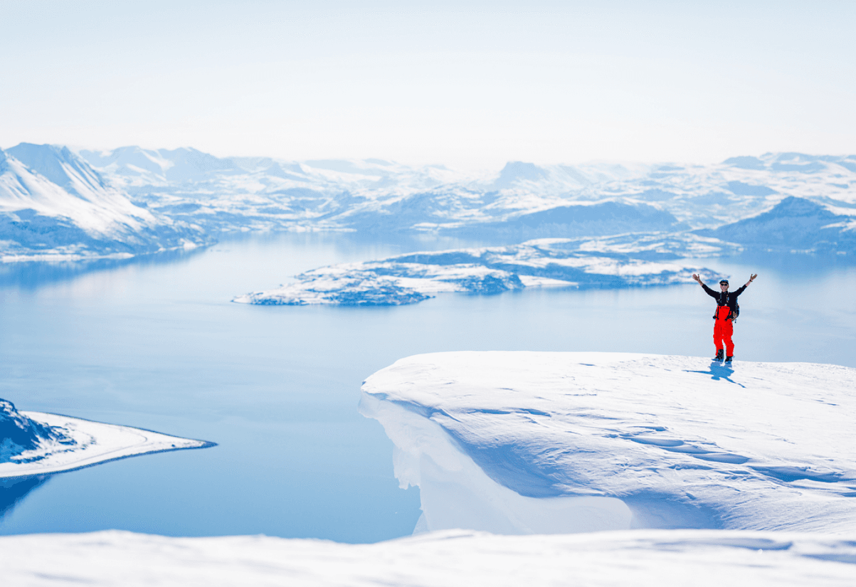 A guy stands on top of a Mountain in the Lyngen Alps