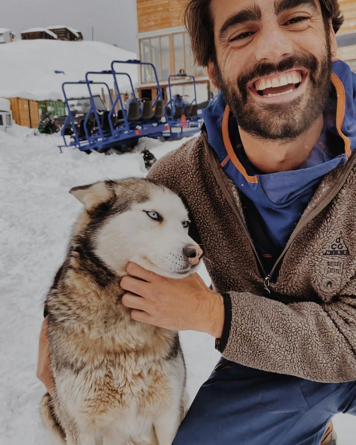 Man smiling and holding a dog 