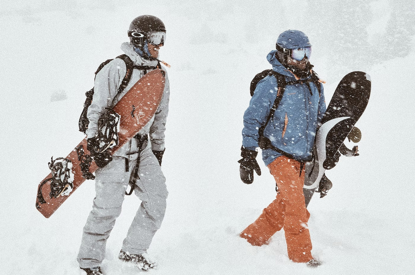 Jorge Abian and Tim Weers walking in deep snow in Kyrgyzstan with their snowboards