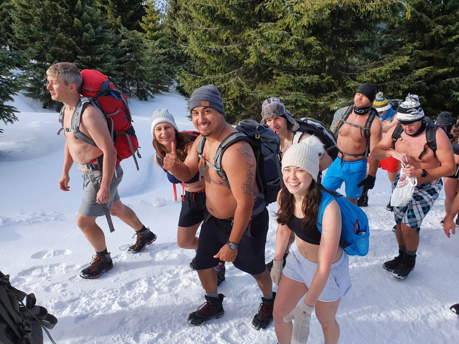 Group of Hikers in Shorts in the Snow with the Wim Hof method.