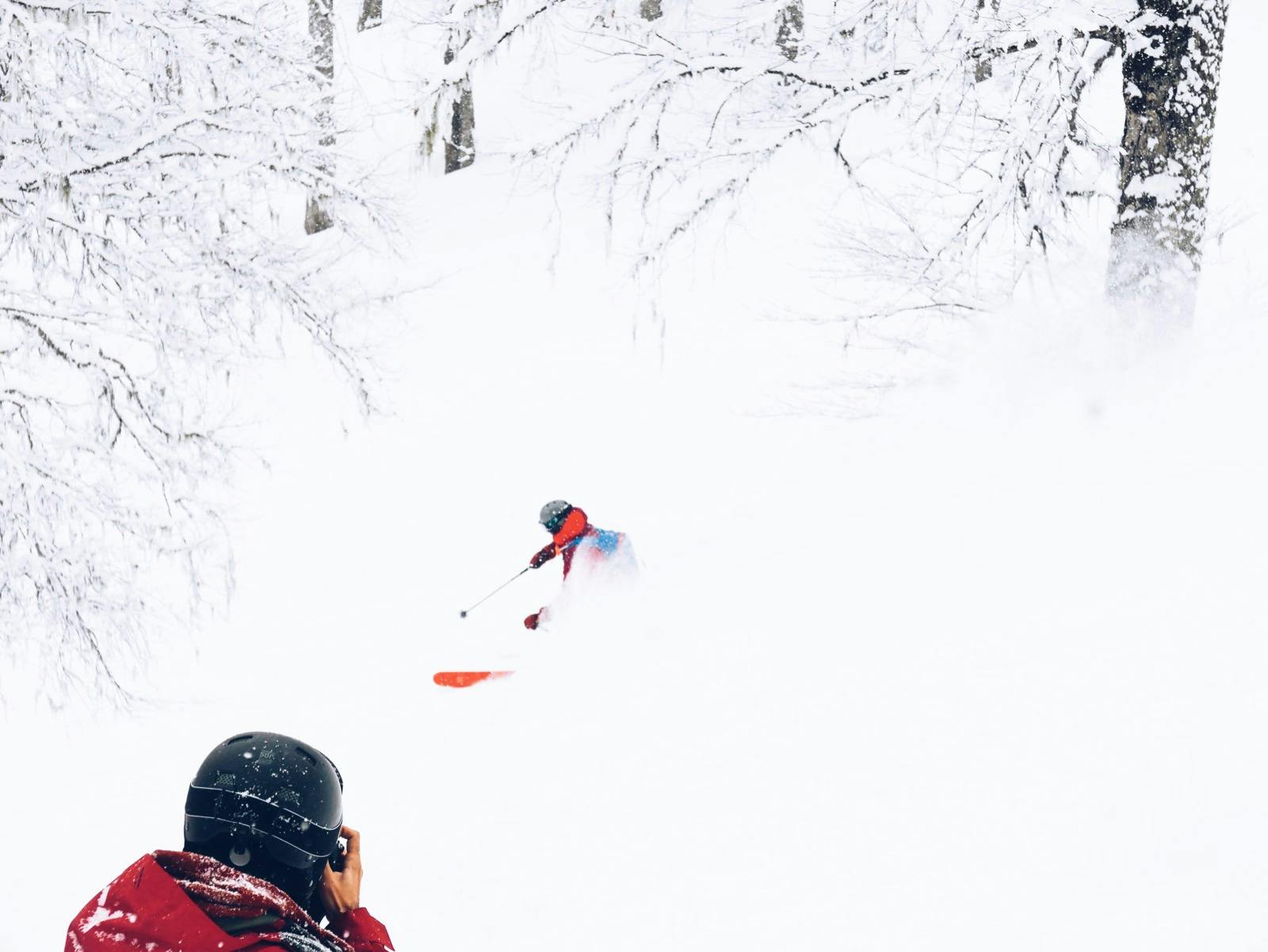 Photographer taking a photo of Skier in the powder snow