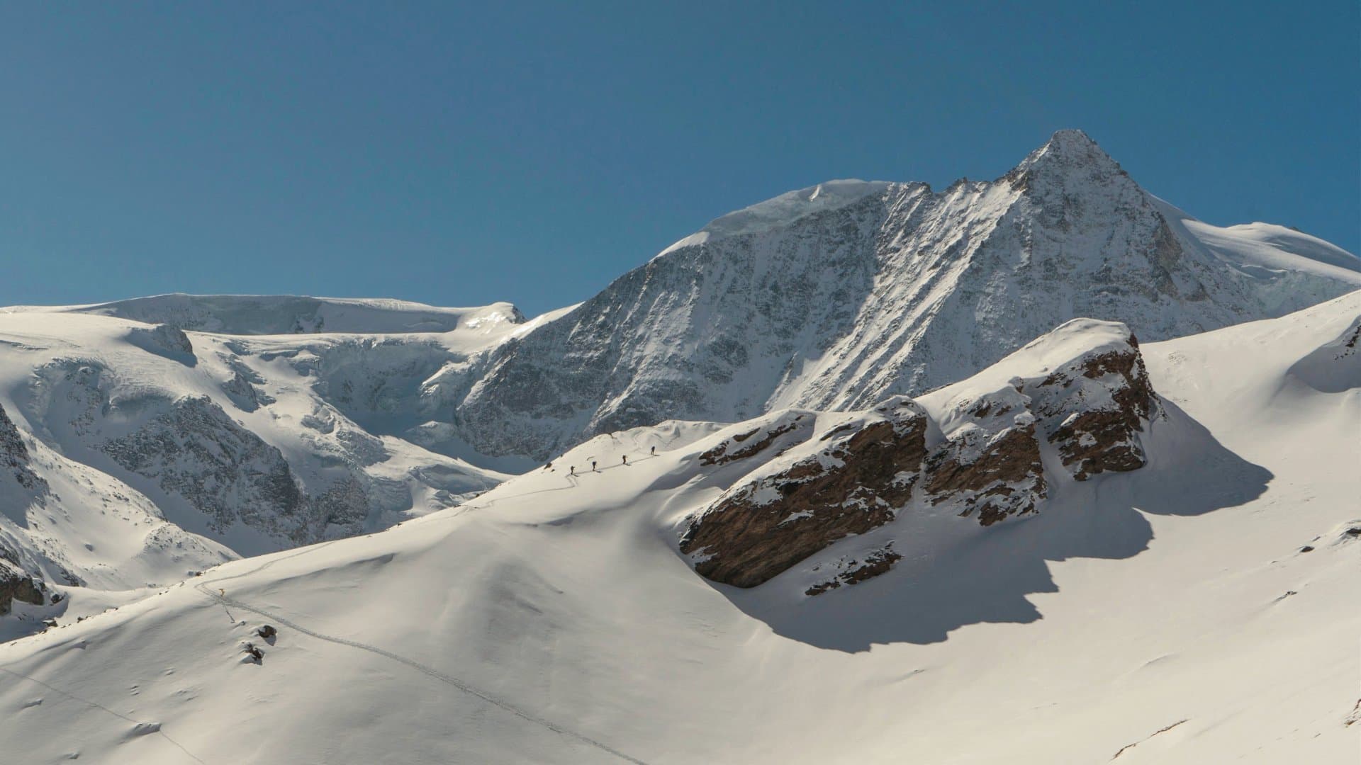 Friends over a hill ski touring in the Alps