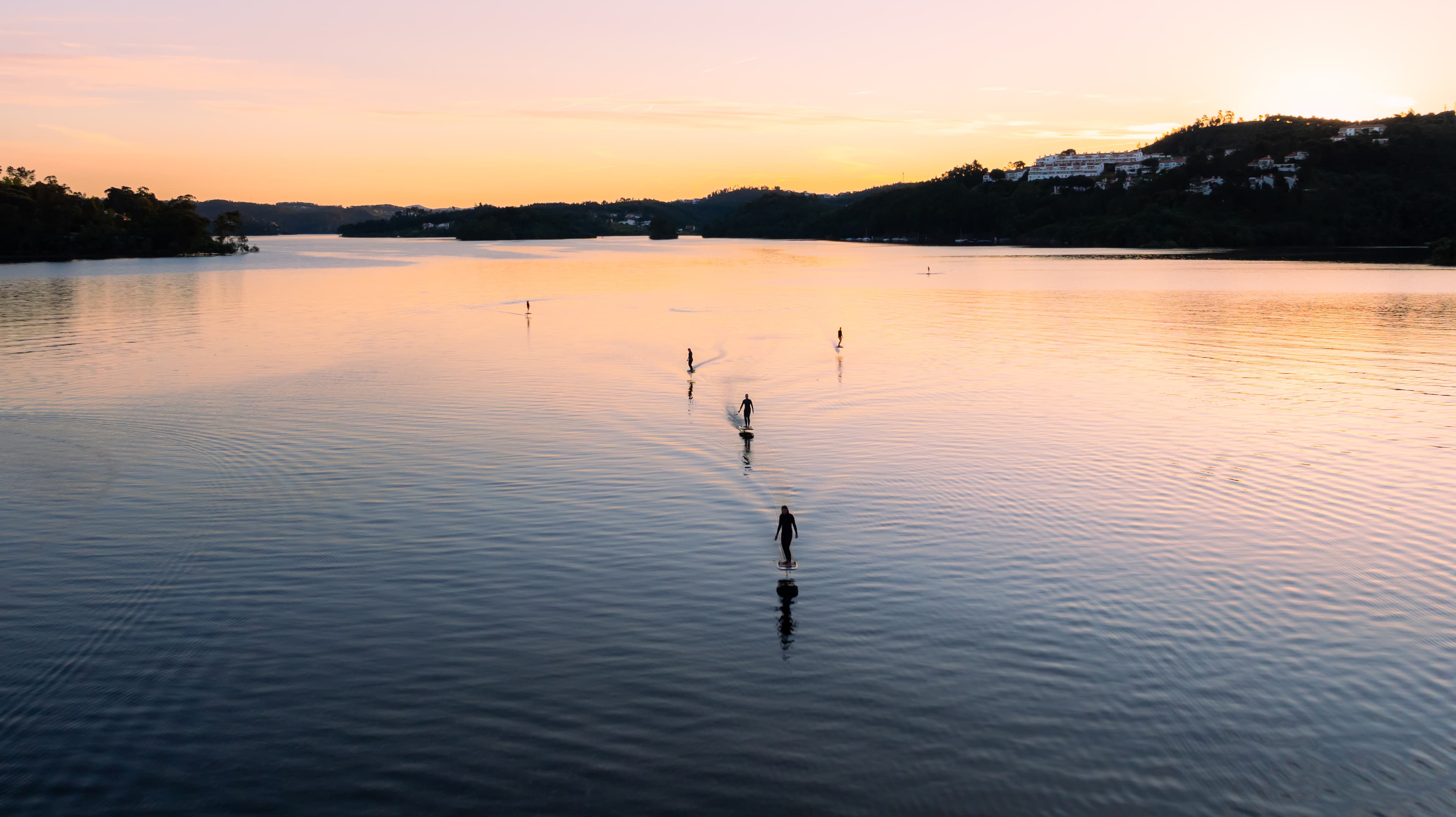 Group of girls riding efoils in the sunset